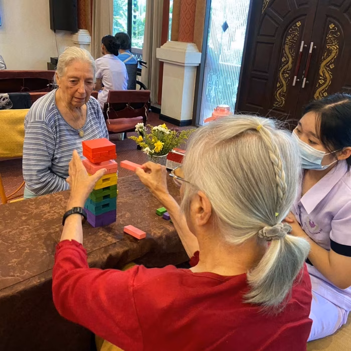 Residents and staff working on a craft activity outdoors.