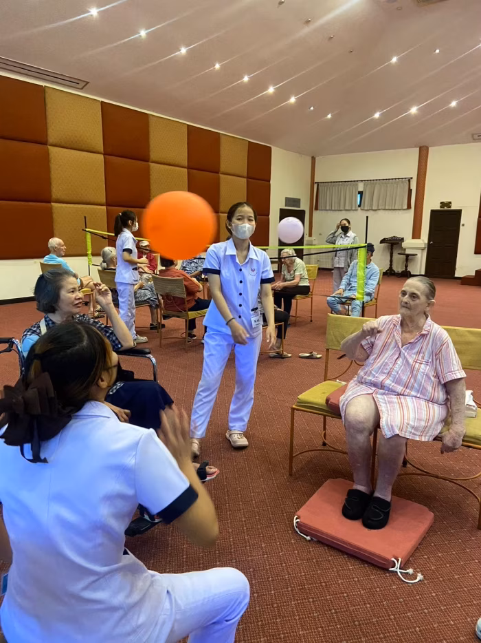Group exercise with a ball, staff and residents.