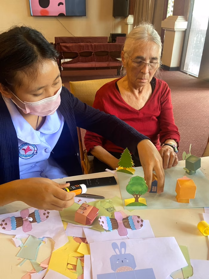 A carer helping a resident with a craft activity.