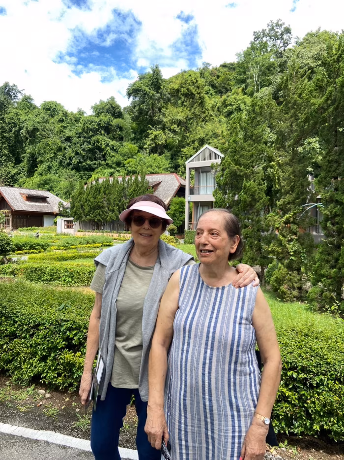 Two residents in the garden, one in a sun hat.