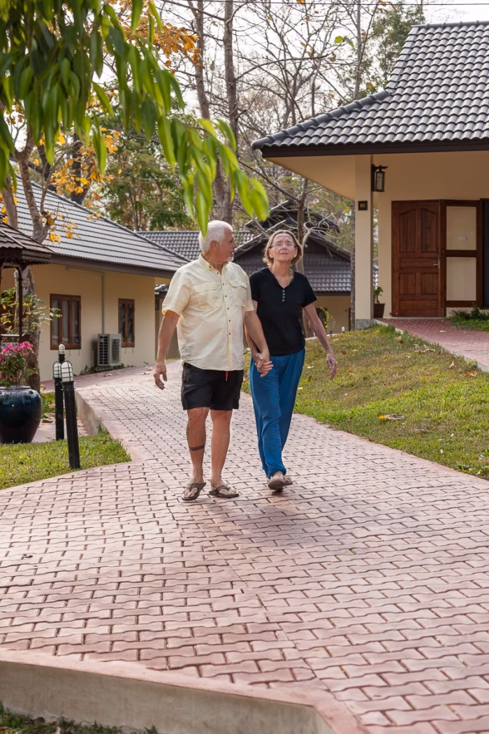 Two residents walking together along a garden path.