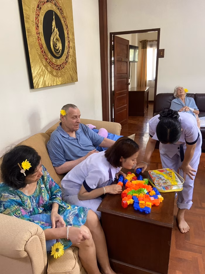 Staff and family gathered around a resident for an activity.