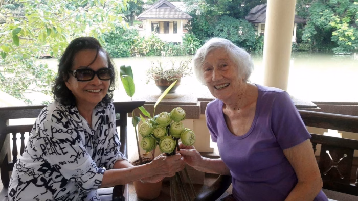 Two residents exchanging fruit on the lakeside terrace.