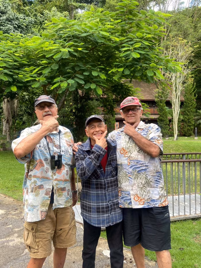 Three residents posing together outdoors.
