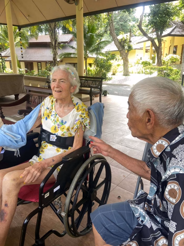 Two residents seated together outdoors.