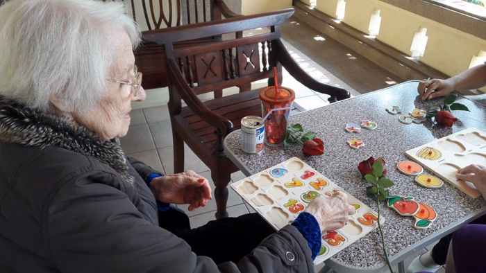 A resident at a table with a spread of small dishes.