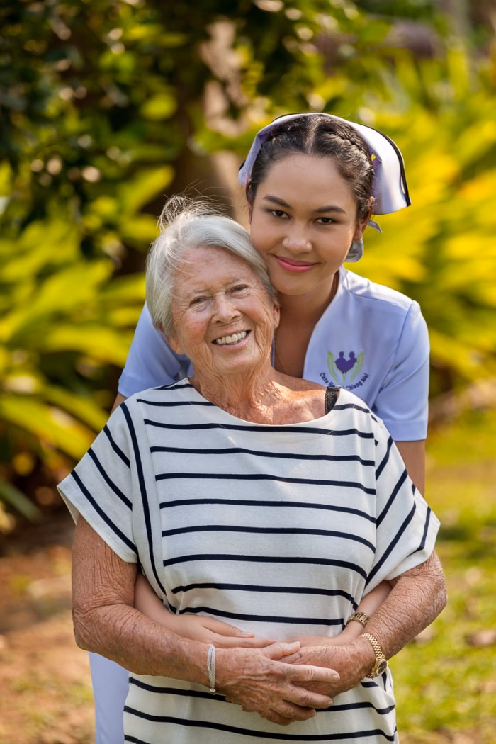 A carer embracing a resident outdoors.