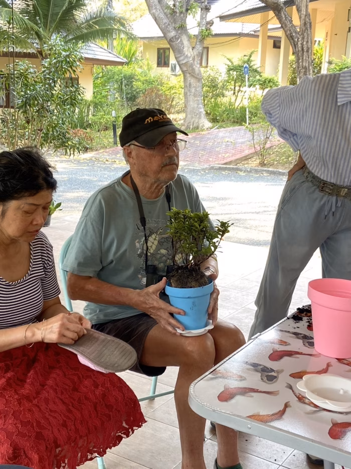 Staff and residents potting plants together.
