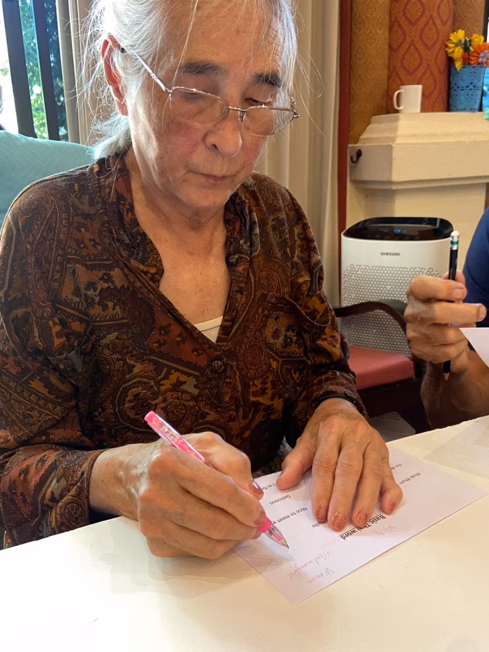 A resident writing at a table.