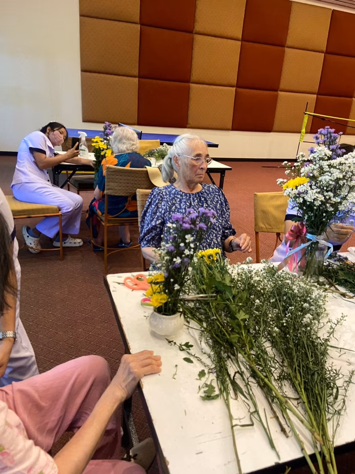 A resident with flowers at the table.