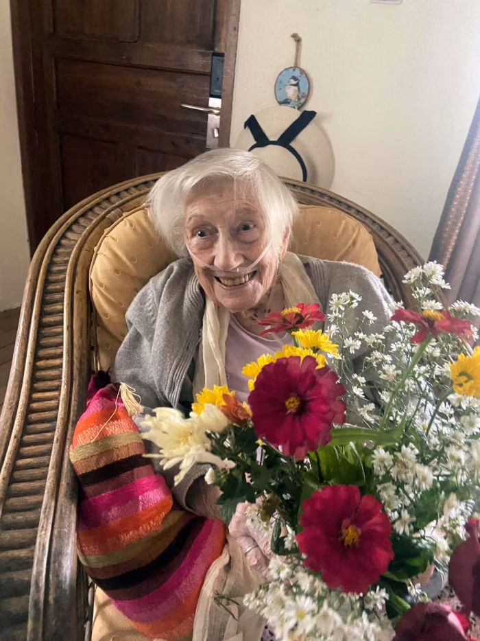 A resident holding a large bouquet of flowers.