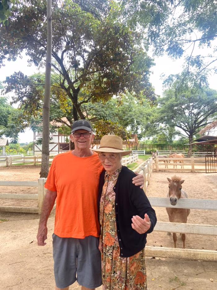Two residents posing by the garden fence.