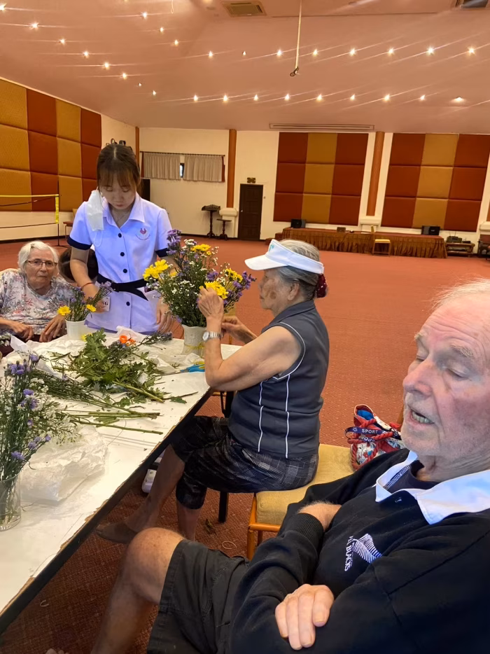 Residents and staff at an activity table in the function hall.