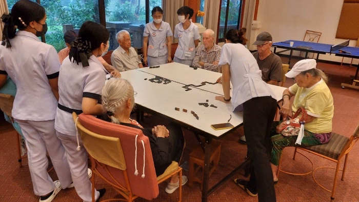 Staff and residents gathered around a large board game.