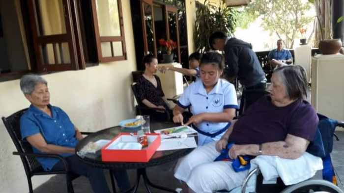 Residents and staff at an outdoor table game.