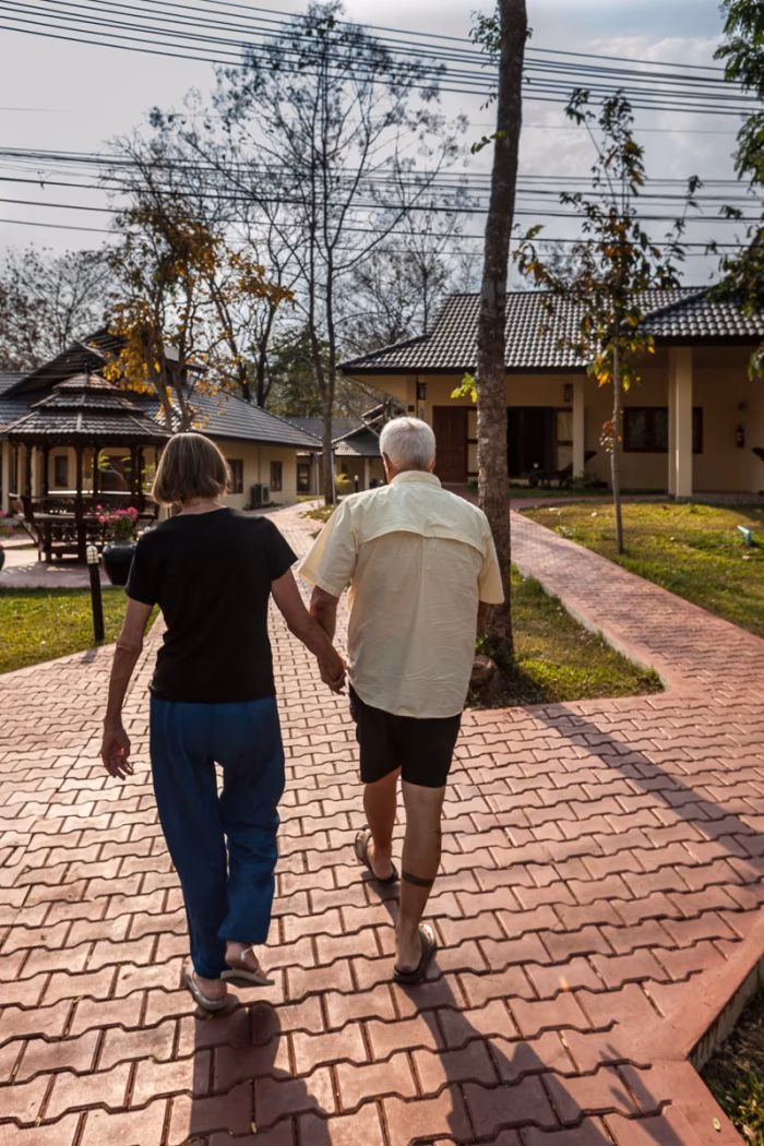 Two residents walking together down a garden path.