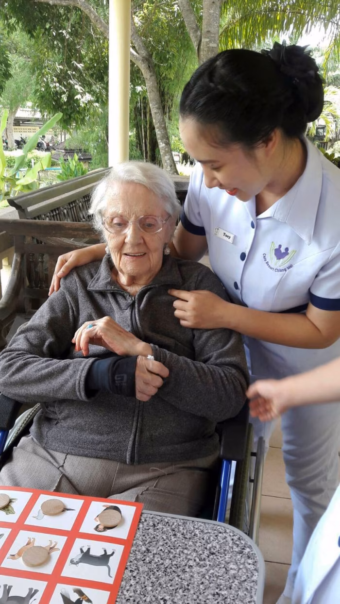 A carer helping a resident with a craft activity.