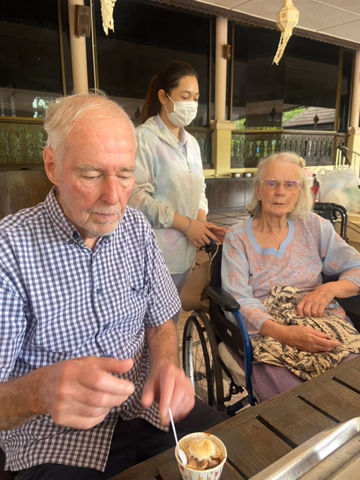 Two residents and a carer on the terrace.