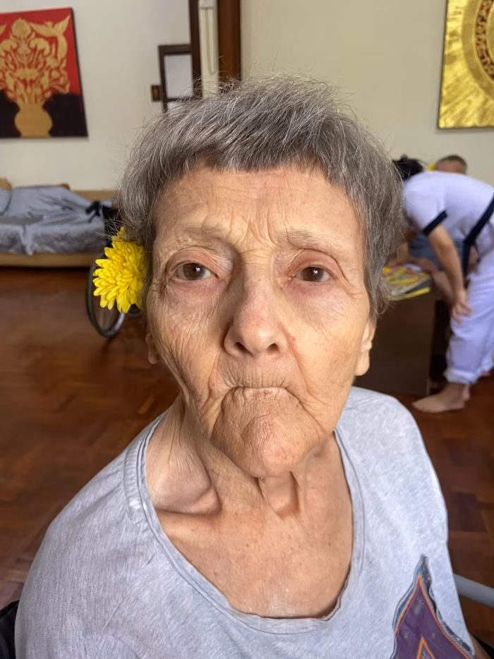A resident with a flower behind her ear, close portrait.