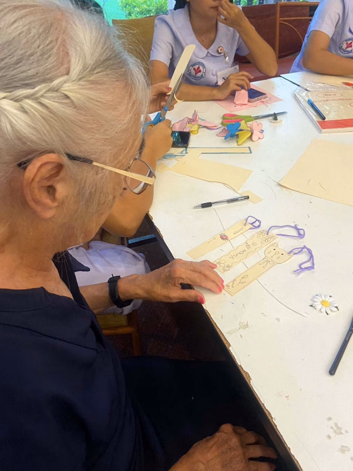 A resident working on a beading activity, close view.
