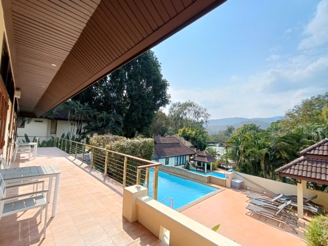 Resort pool with villas and mountains in the background.